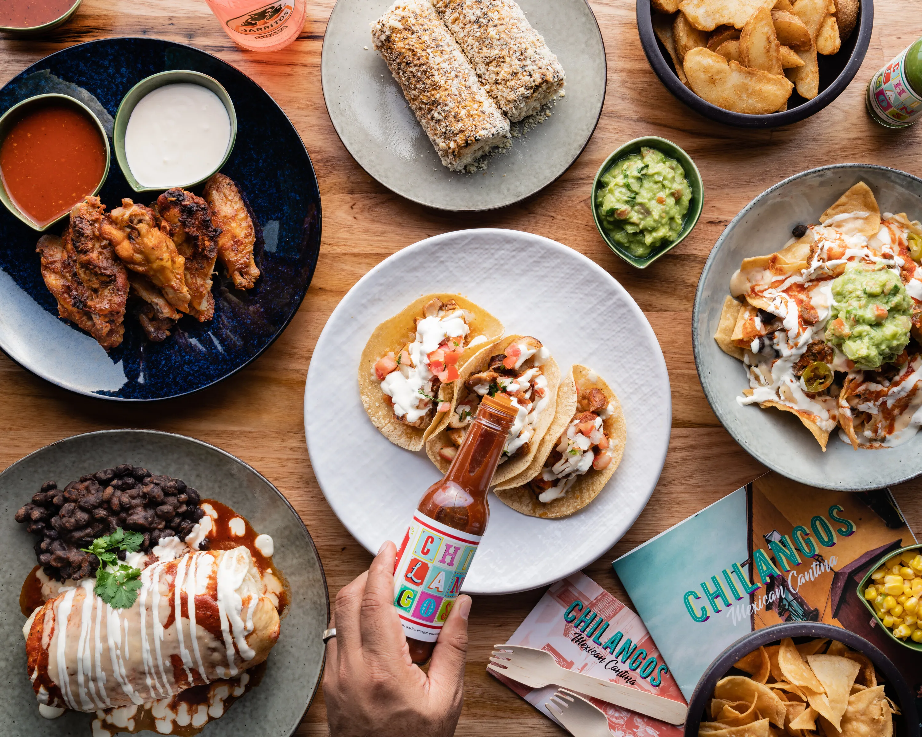 Tacos, nachos, wings and burritos spread across a table